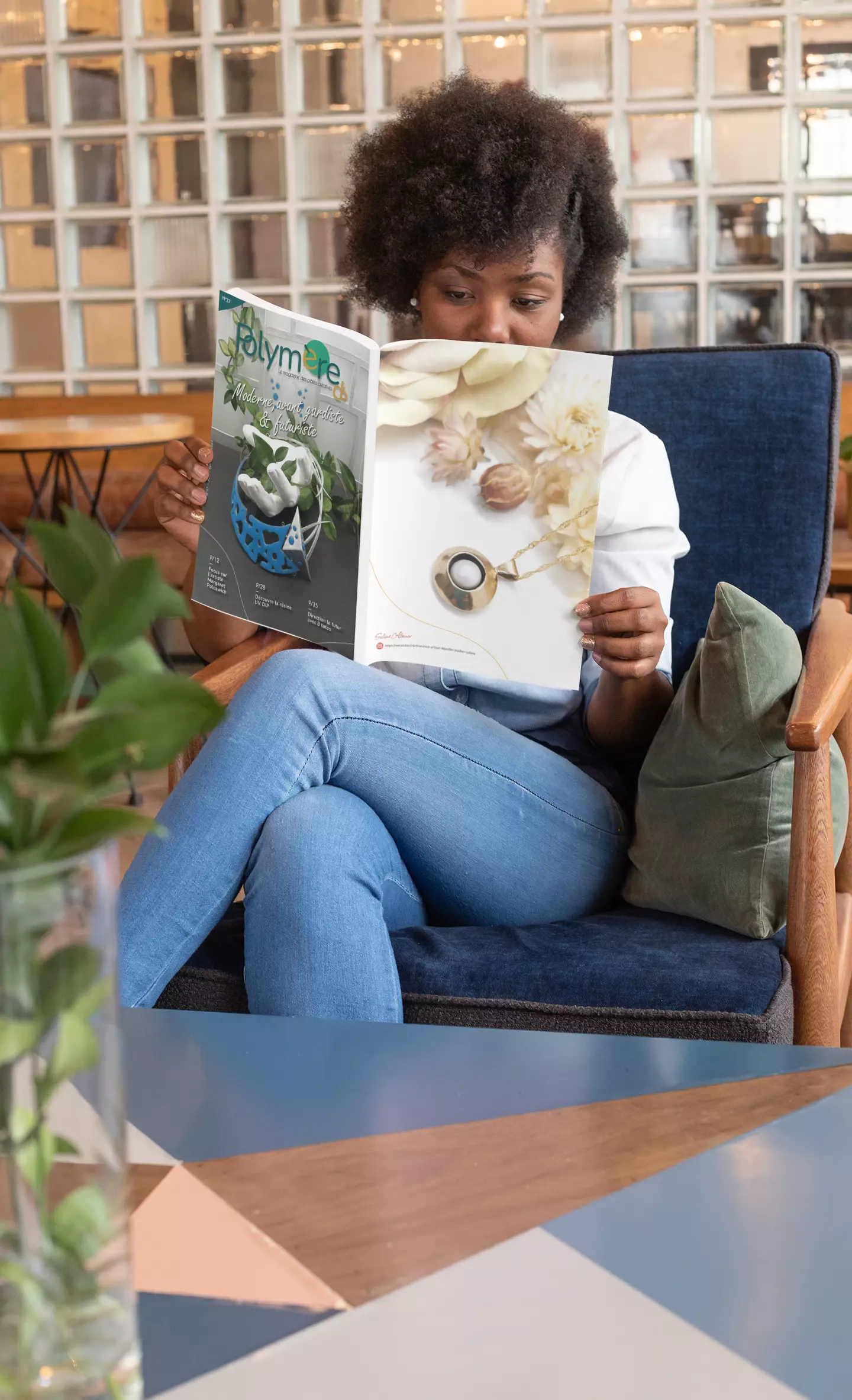 Femme dans un café moderne lisant le magazine Polymère & Co N°37 moderne futuriste avant gardiste