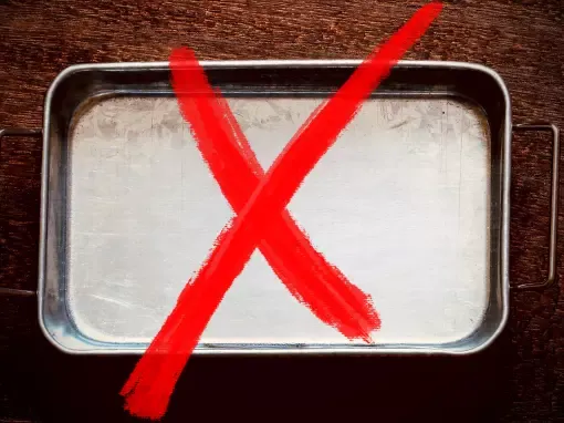 Plat en métal avec une croix rouge montrant qu'il n'est pas recommandé d'utiliser ce genre de plat pour la cuisson de l'argile polymère