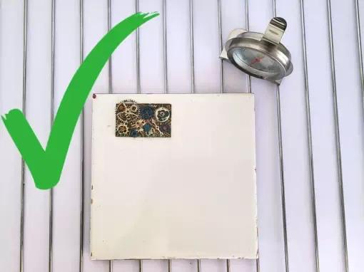 Cuisson correcte d'une création en pâte polymère posée sur un carreau de céramique lui même posé sur une grille de four munie d'un thermomètre de four